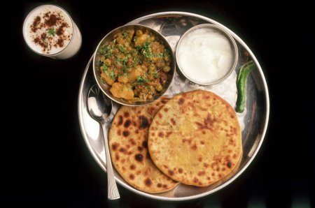 Snacks , patato Parathas curd and vegetable curry with butter milk , indian breakfast