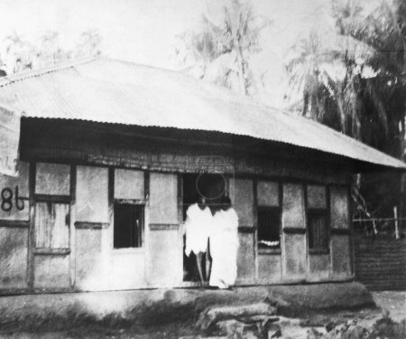 Foto de Mahatma Gandhi y Manu Gandhi dejando una cabaña en Noakhali Bengala Oriental, noviembre 1946, India - Imagen libre de derechos