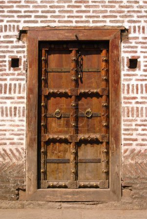 Richly wood carved door fixed in brickwork at entrance of Vishrambaug Wada second palace of Peshve the Maratha king ; Pune ; Maharashtra ; India