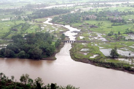 Téléchargez les photos : Une vue aérienne de terres agricoles immergées dans une inondation a basculé à Raigad, Maharashtra, Inde Le 26 juillet 2005 - en image libre de droit