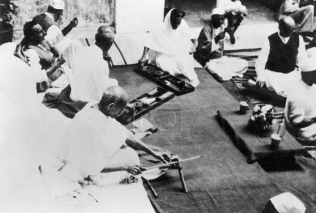 Téléchargez les photos : Mahatma Gandhi, Mahadev Desai et d'autres filant, Bardoli, 1939, Inde - en image libre de droit