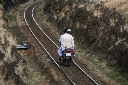 Foto de Los hombres que viajan en moto Gauge Railway line Miraj Maharashtra India Asia - Imagen libre de derechos