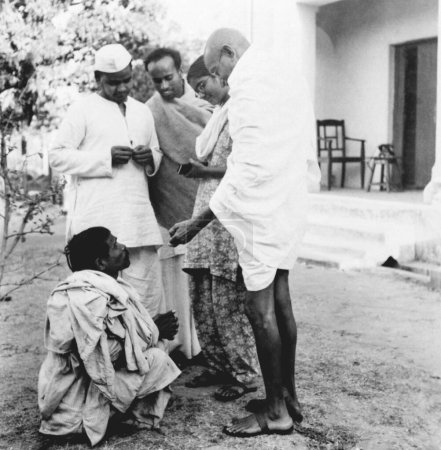 Téléchargez les photos : Mahatma Gandhi, saluant un aveugle lors de sa visite dans les zones touchées par les émeutes du Bihar, 1947, Inde - en image libre de droit