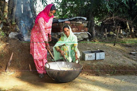 Foto de Mujeres rurales mezclando ingredientes hirvientes haciendo jabón lavado iniciativa económica iniciada por ONG Chinmaya Organización de Desarrollo Rural CORD, Sidhbari, Himachal Pradesh, India - Imagen libre de derechos