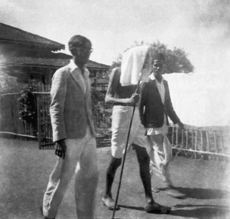 Foto de Mahatma Gandhi caminando con dos visitantes en el Ashram Sevagram, 1940 - Imagen libre de derechos