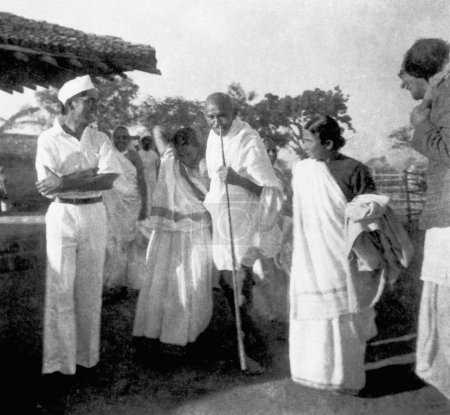 Foto de Mahatma Gandhi caminando con los coashramitas Johrabehn y Lilavatibehn en el Ashram Sevagram, 1939 - Imagen libre de derechos