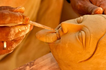 Foto de Escultor dando toques finales a la diosa Durga Kali escultura hecha de arcilla para la celebración de Durga Pooja; Rajkot; Gujarat; India - Imagen libre de derechos