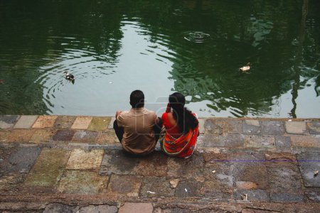 Téléchargez les photos : Couple assis sur la rive du réservoir Banganga à Walkeshwar, Mumbai, Maharashtra, Inde - en image libre de droit