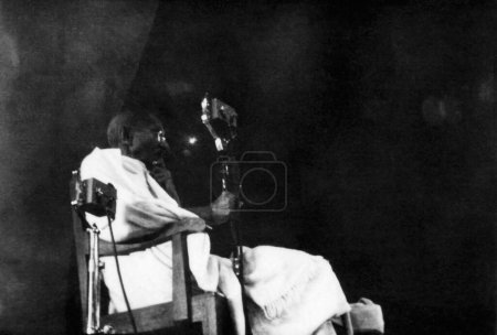 Photo for Mahatma Gandhi speaking into a mike, 1942, India - Royalty Free Image