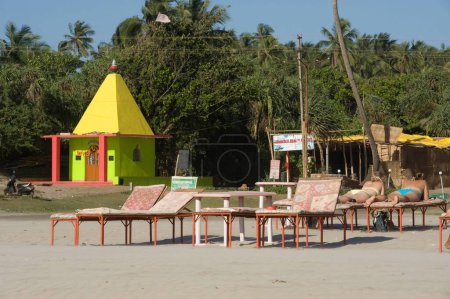 Foto de Templo y Turistas duermen en silla en Arambol Beach Goa India Asia - Imagen libre de derechos
