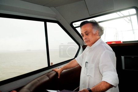 Photo for Jairam ramesh in speed boat to review oil spill situation Bombay Mumbai ; Maharashtra ; India - Royalty Free Image