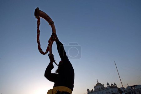 Photo for Sikh devotee blowing trumpet during celebrations of Guru Granth Sahib Nanded, Maharashtra, India - Royalty Free Image