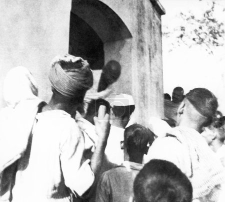 Foto de Mahatma Gandhi, dejando un edificio durante su visita a las zonas afectadas por los disturbios de Bihar, 1947, India - Imagen libre de derechos