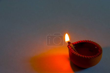 Foto de Una lámpara de aceite de arcilla diya una fuente de luz como llama sobre fondo blanco - Imagen libre de derechos