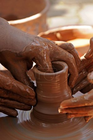 Photo for Teacher and kid making ceramic pot on pottery wheel - Royalty Free Image