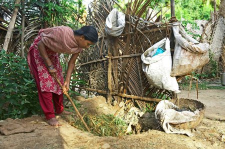 Foto de Voluntario de la ONG Chinmaya Organización de Desarrollo Rural CORD haciendo estiércol de compost a partir de residuos orgánicos en boxes, Siruvani, Karnataka, India - Imagen libre de derechos