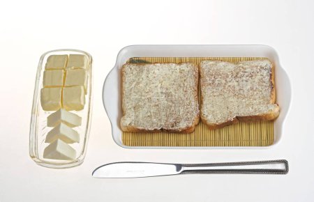 Foto de Pan tostado con mantequilla untada y trozos de cubos de queso y mantequilla y cuchillo - Imagen libre de derechos