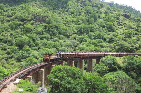 Téléchargez les photos : Personnes prenant des risques en voyageant sur le toit du train allant sur le pont, Rajasthan, Inde - en image libre de droit