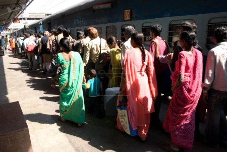 Téléchargez les photos : Voyageurs en file d'attente pour monter à bord d'un train à la gare, Ahmedabad, Gujarat, Inde - en image libre de droit