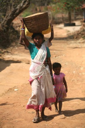Téléchargez les photos : Dame et fille avec fille derrière sa charge de transport sur la tête, Jharkhand, Inde - en image libre de droit