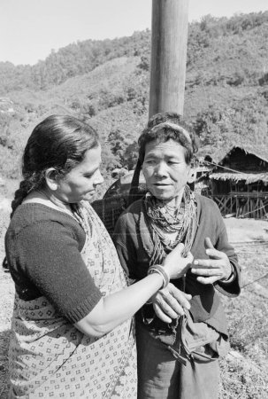 Photo for Mrs. TS Satyan meets with lady from Hill Miri tribe of Subansiri district in Arunachal Prdesh admires her ornament, Arunachal Pradesh, India 1982 - Royalty Free Image