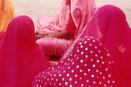 Téléchargez les photos : Cinq femmes indiennes rurales dans des sarees roses assis et parlant Kumbh Fair Hardwar Uttar Pradesh Inde - en image libre de droit