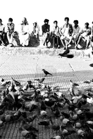 Téléchargez les photos : Hommes et pigeons nourrissant Marine Drive Mumbai Maharashtra Inde Asie 1987 - en image libre de droit