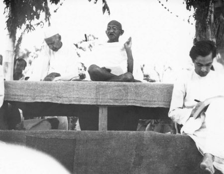 Photo for Mahatma Gandhi talking to people while taking sunbath village Dasgharia Noakhali East Bengal Kanu Gandhi stayed from November - Royalty Free Image