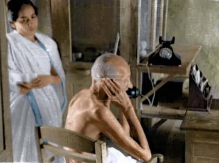 Foto de Mahatma Gandhi hablando por teléfono desde la cabaña de oficinas, Wardha, India, Asia, 1940 - Imagen libre de derechos