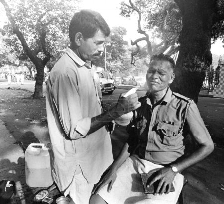 Photo for Man making shaving of police constable, India - Royalty Free Image