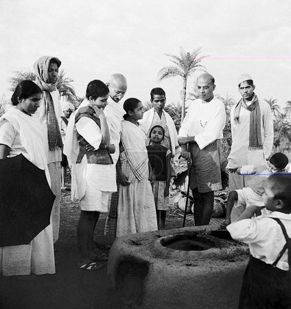 Téléchargez les photos : Durga Mehta, Mahatma Gandhi, Abha Gandhi, JC Kumarappa et d'autres à l'ashram de Sevagram, 1940 - en image libre de droit