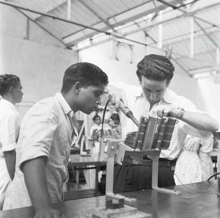 Foto de Hombres soldando un instrumento, fábrica de teléfono, fabricación de instrumentos telefónicos en Bangalore, Karnataka, India, año 1950 - Imagen libre de derechos