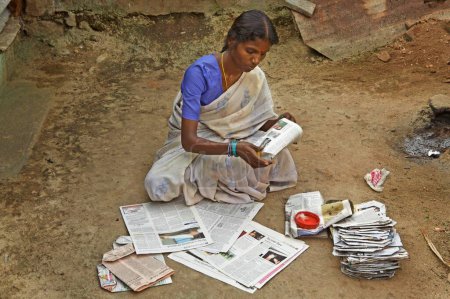 Téléchargez les photos : Bénévole de l'ONG Chinmaya Organization of Rural Development CORD fabriquant des sacs en papier recyclé à partir de vieux journaux, Siruvani, Karnataka, Inde - en image libre de droit