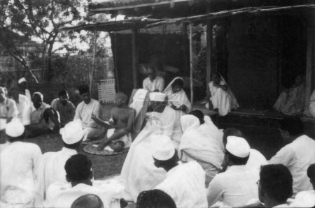 Foto de Mahatma Gandhi hablando con un grupo de personas Sevagram Ashram, 1939 Thakkar Bapa, Mahadev Desai, Rajkumari Amrit Kaur, Kasturba Gandhi, India - Imagen libre de derechos