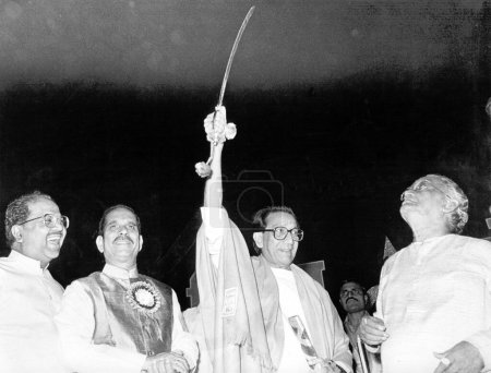 Photo for Shiv Sena supremo Bal Thackeray holding sword along with party leaders Pramod Navalkar and Manohar Joshi in public rally in Bombay now Mumbai, Maharashtra, India - Royalty Free Image
