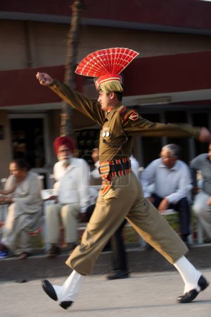 Téléchargez les photos : Soldat des forces de sécurité frontalières indiennes faisant un défilé avant de commencer la cérémonie de changement de garde à la frontière de Wagah, Amritsar, Punjab, Inde - en image libre de droit