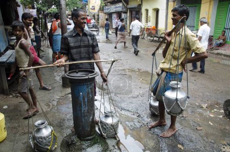 Téléchargez les photos : Les travailleurs des fournisseurs d'eau bavardent au robinet public Kolkata Bengale occidental Inde Asie - en image libre de droit