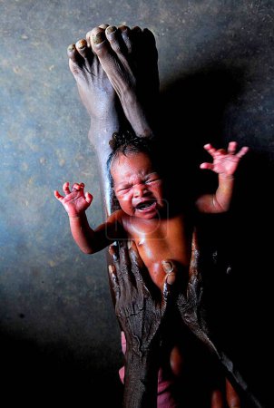 Foto de Ho tribus partera dando bebé aceite exfoliante, Chakradharpur, Jharkhand, India - Imagen libre de derechos