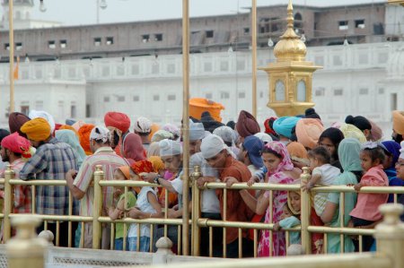 Téléchargez les photos : Les dévots attendent au pont des gourous qui mène au Harmandir, temple d'or, Amritsar, Punjab, Inde - en image libre de droit
