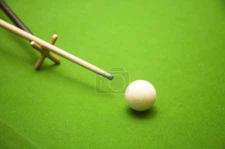 Photo for Billiard stick on support ready to push the white ball on the green table ; Indoor game ; Palolem beach ; Goa ; India - Royalty Free Image