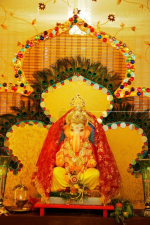 Elegant idol of lord Ganesh ganpati elephant headed god wear pearl necklace and synthetic gem studded jewellery with beautiful decoration all around done with synthetic gems ; Bombay Mumbai ; Maharashtra ; India