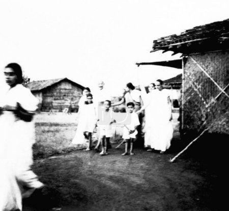 Téléchargez les photos : Mahatma Gandhi et d'autres marchant sur le campus de l'Ashram de Sevagram, 1938, Sushila Nayar - en image libre de droit