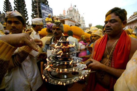Téléchargez les photos : Prêtre exécutant poja de l'idole du seigneur khandoba pendant la célébration de dasshera au temple jejuri, pune, Maharashtra, Inde - en image libre de droit