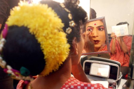 Téléchargez les photos : Artiste masculin appliquant eye liner se préparer pour le spectacle Bin Baicha Tamasha, Inde - en image libre de droit
