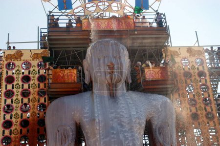 Foto de Leche vertiendo sobre la cara de 57 pies de altura estatua del señor Bahubali conocido como Gomateshvara en Mahamasthakabisheka celebración, Sravanabelagola en el distrito de Hassan de Karnataka, India - Imagen libre de derechos
