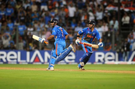 Téléchargez les photos : Batteur indien L Gautam Gambhir, MS Dhoni courir entre guichets lors de la finale de la Coupe du monde 2011 ICC entre l'Inde et le Sri Lanka au stade Wankhede le 2 Avril 2011 à Mumbai en Inde - en image libre de droit