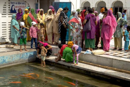 Téléchargez les photos : Femme baignant enfant au temple d'or, amritsar, punjab, Inde, Asie - en image libre de droit