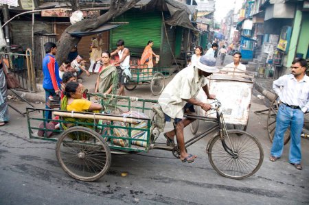 Photo for Street scene, cycle rickshaw riders with passengers, Calcutta now Kolkata, West Bengal, India - Royalty Free Image