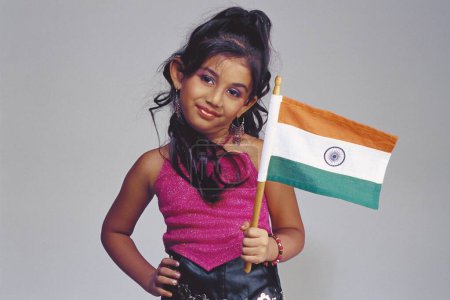 Téléchargez les photos : Enfant habillé comme mannequin, fille portant un costume moderne et tenant le drapeau indien - en image libre de droit
