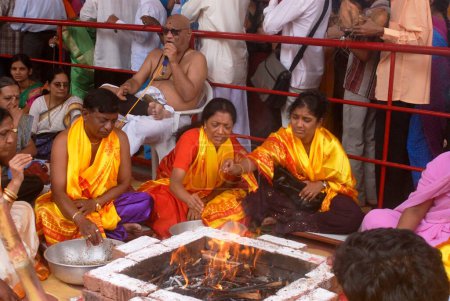 Foto de Homa, Parejas encendieron fuego sagrado para adorar al Señor Ganesh en Dagdu Seth Halwai Ganapati, festival Ganapati, Pune, Maharashtra, India - Imagen libre de derechos